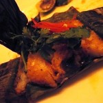 Grilled white fillet of fish with lemongrass wrapped in banana leaves